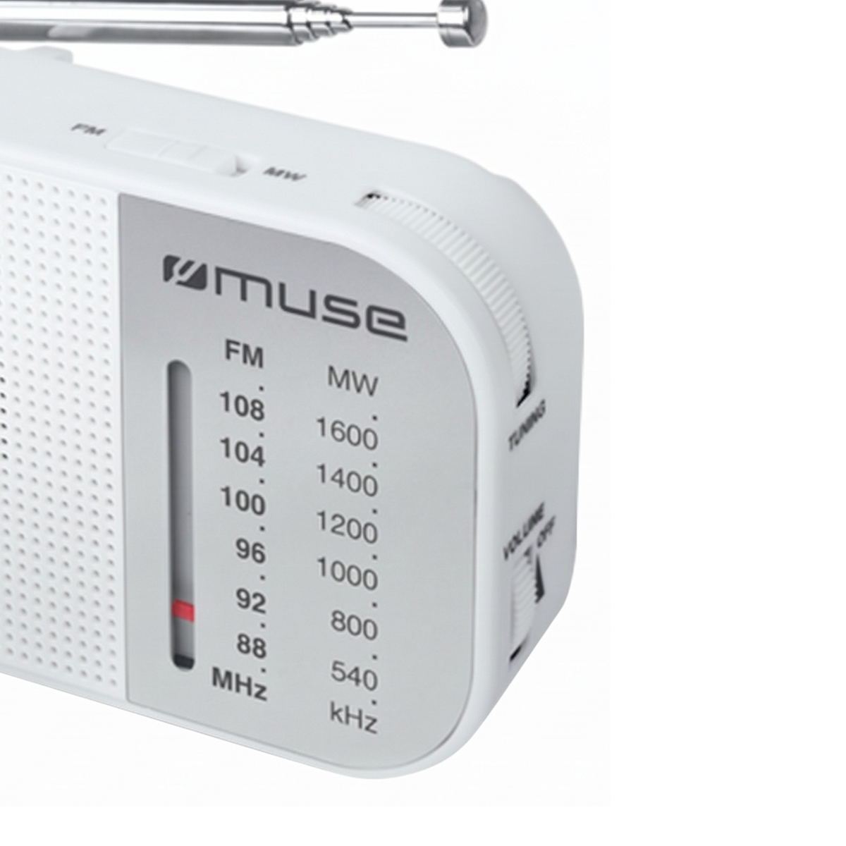 Primer plano de una radio blanca Muse con panel plateado, escalas de frecuencia FM y MW, y diales laterales.