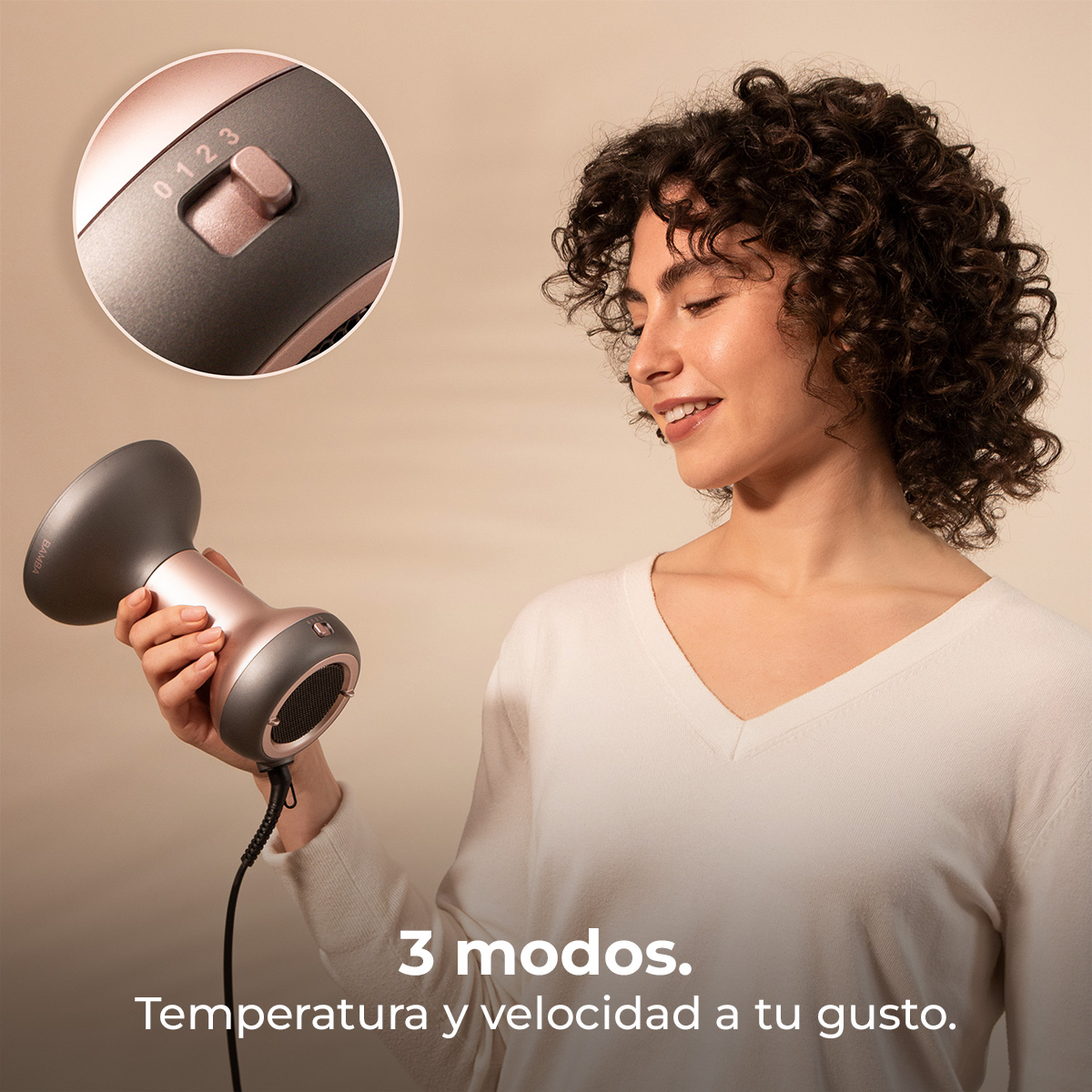 Una donna tiene in mano un phon moderno rosa e grigio con tre velocità.