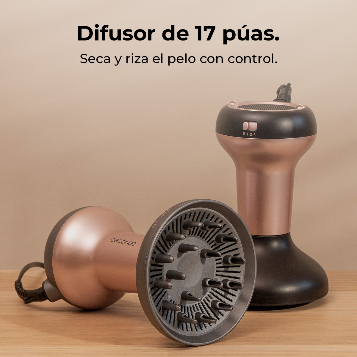 Due diffusori per capelli in oro rosa e nero su un tavolo di legno con testo in spagnolo.