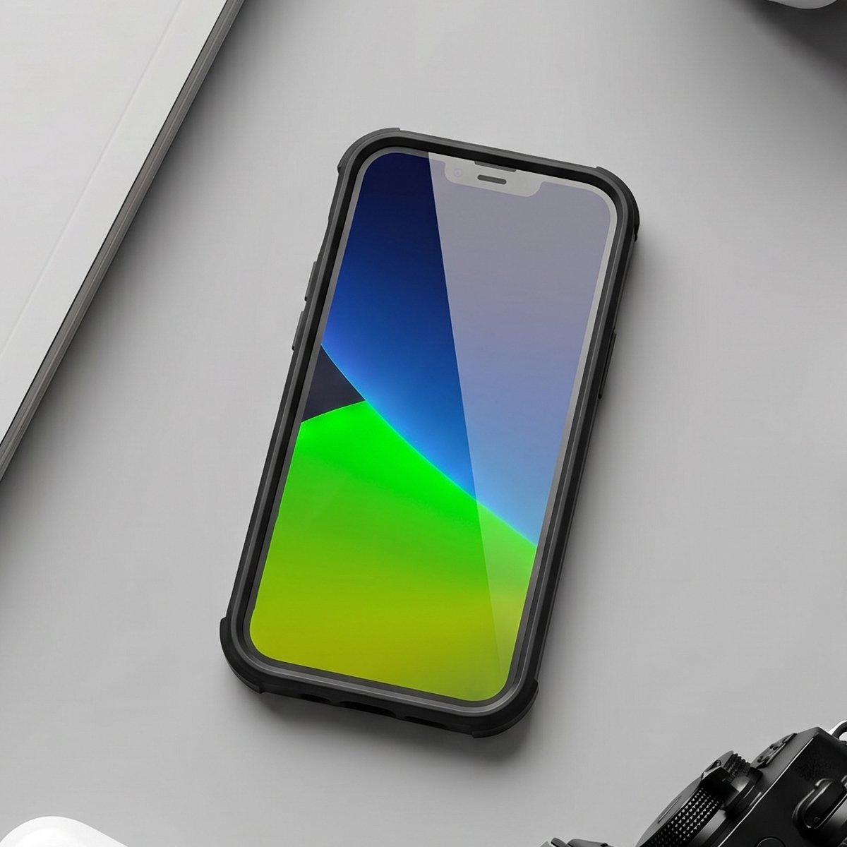 Uno smartphone in custodia protettiva si trova su una superficie grigia, accanto a un documento e una fotocamera.