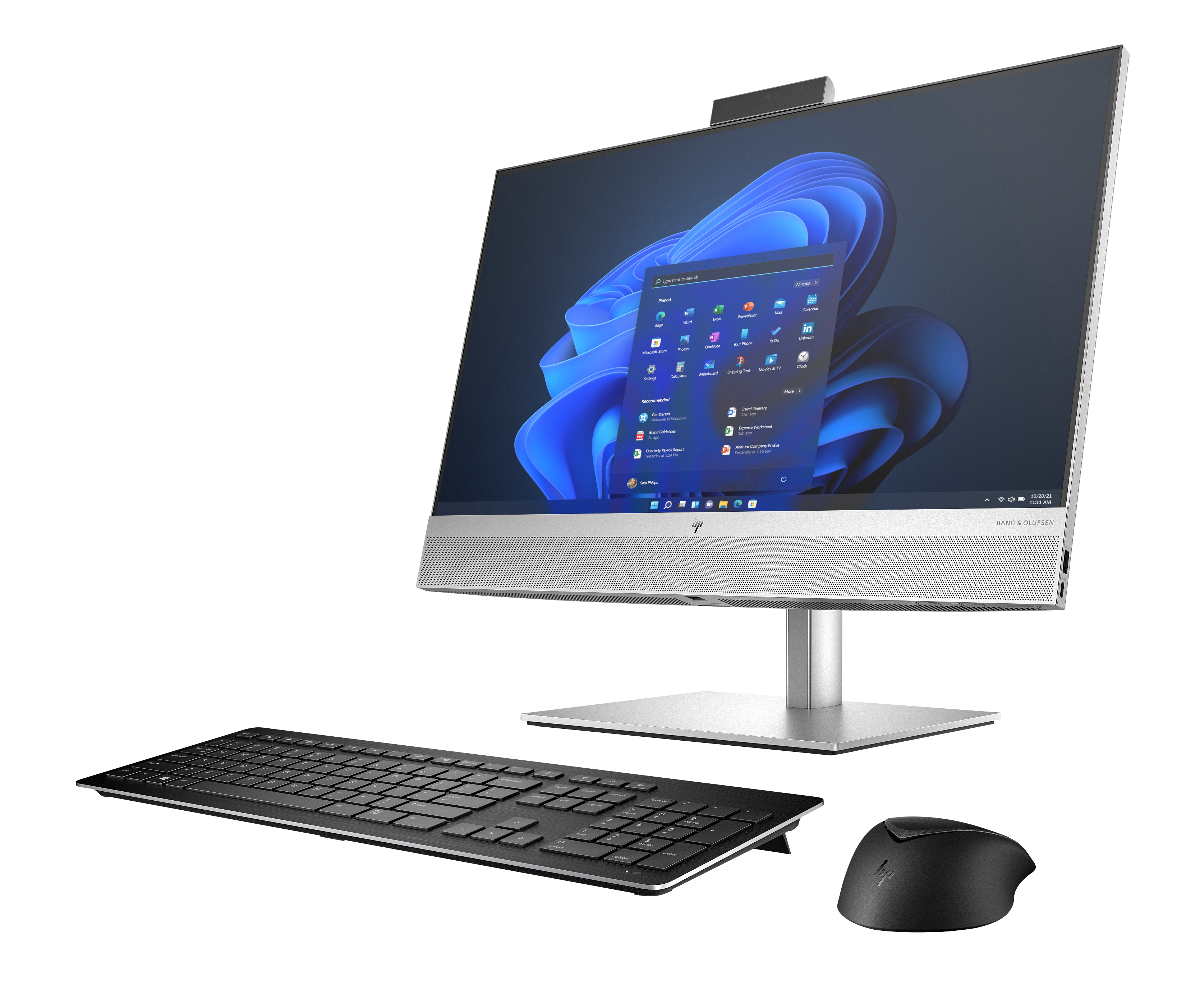 Computer all-in-one con monitor argento, desktop Windows 11, tastiera nera e mouse su sfondo bianco.
