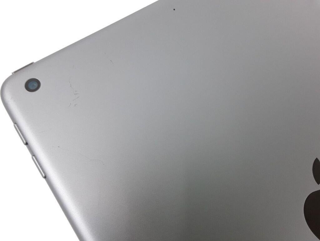 Retro di un tablet argento con obiettivo della fotocamera e graffi.
