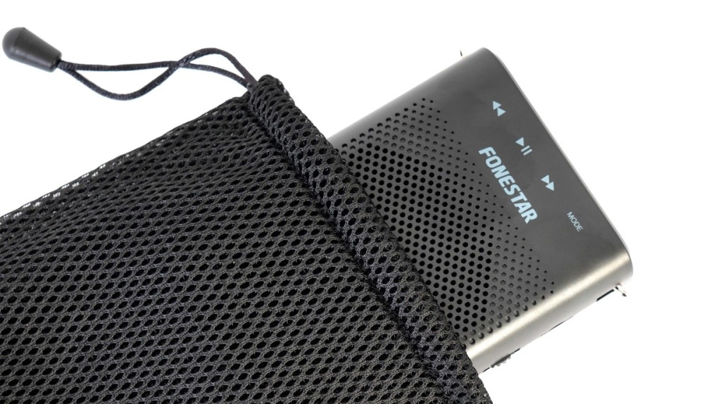 Un altavoz Fonestar negro sale parcialmente de una bolsa de malla negra con cordón sobre un fondo blanco.