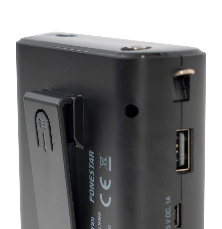 Parte trasera de un dispositivo electrónico negro con clip, puerto USB y marca CE sobre fondo blanco.