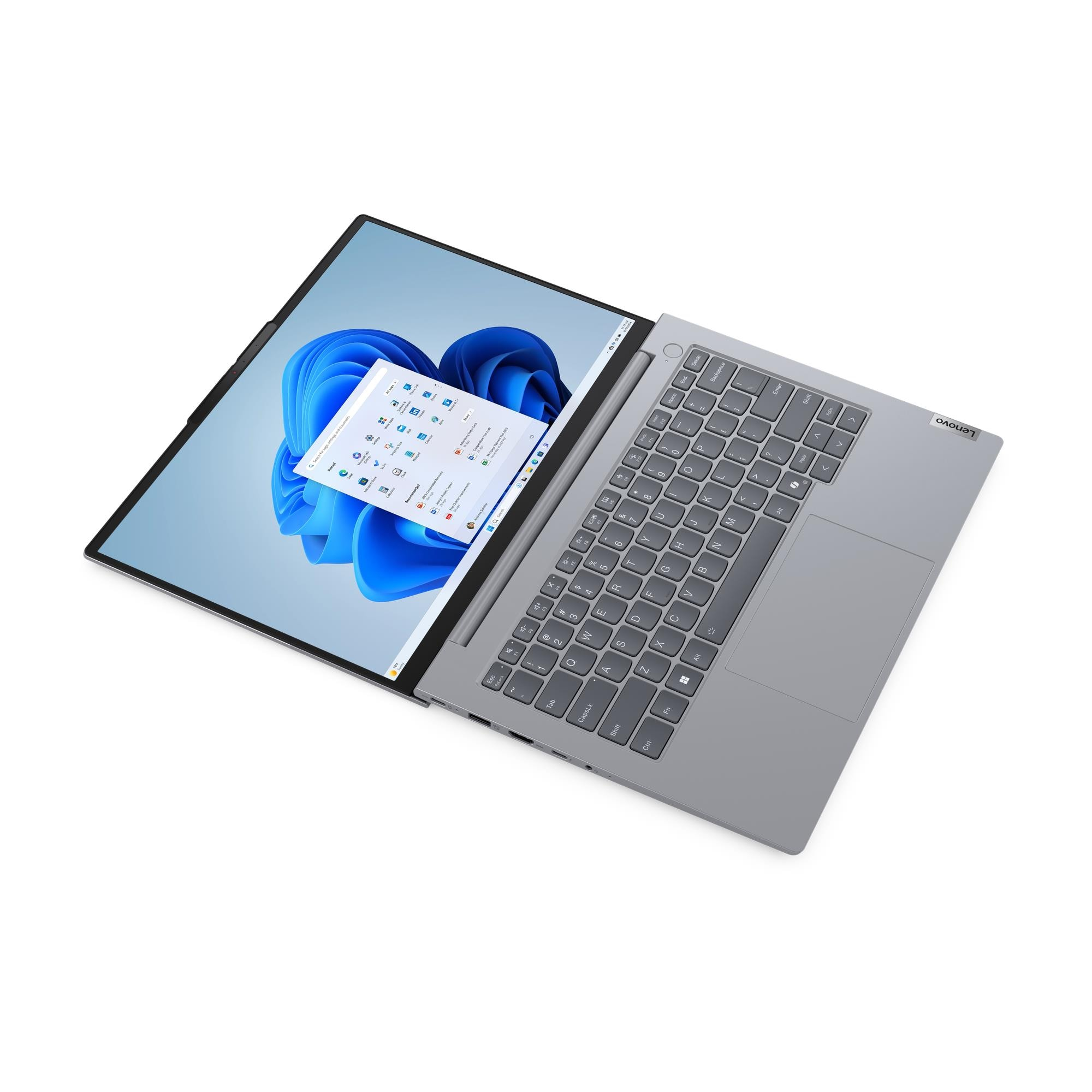 Açık gümüş renkli bir Lenovo dizüstü bilgisayar, mavi bir Windows 11 masaüstü arka planı gösteriyor.