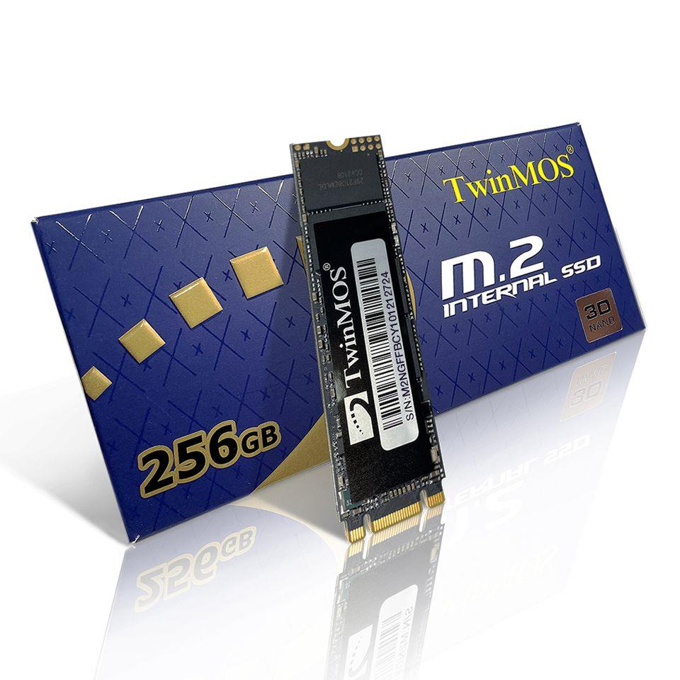 Yansıtıcı beyaz arka plana sahip mavi ambalaj kutusunun önünde bir TwinMOS 256GB M.2 dahili SSD duruyor.