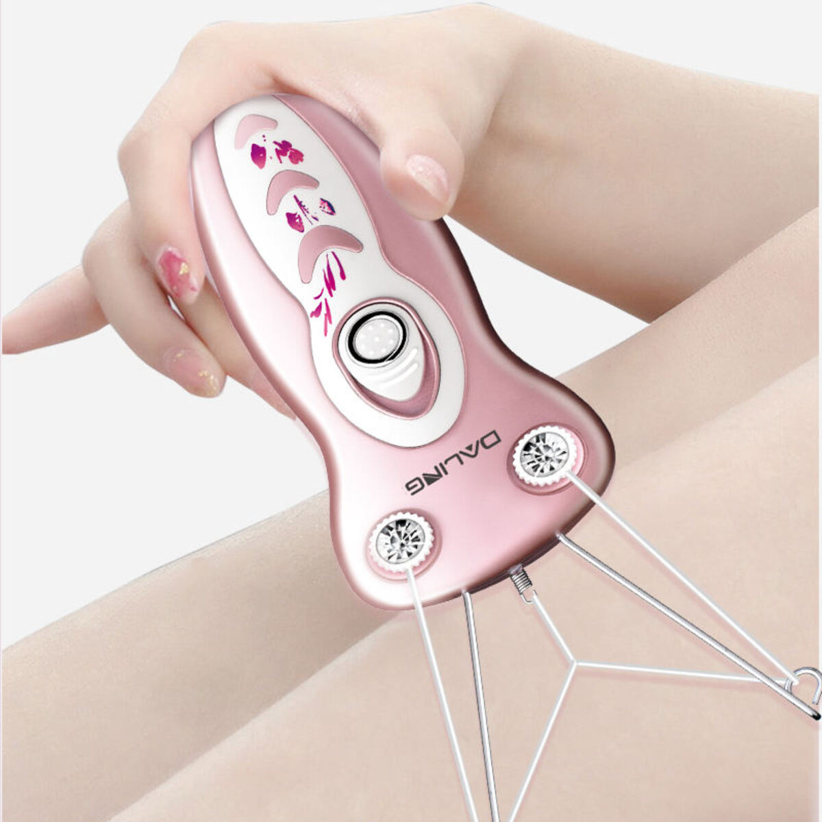 Eine Hand hält ein rosa-weißes Daling Gesichtshaarentfernungsgerät an ein Bein.