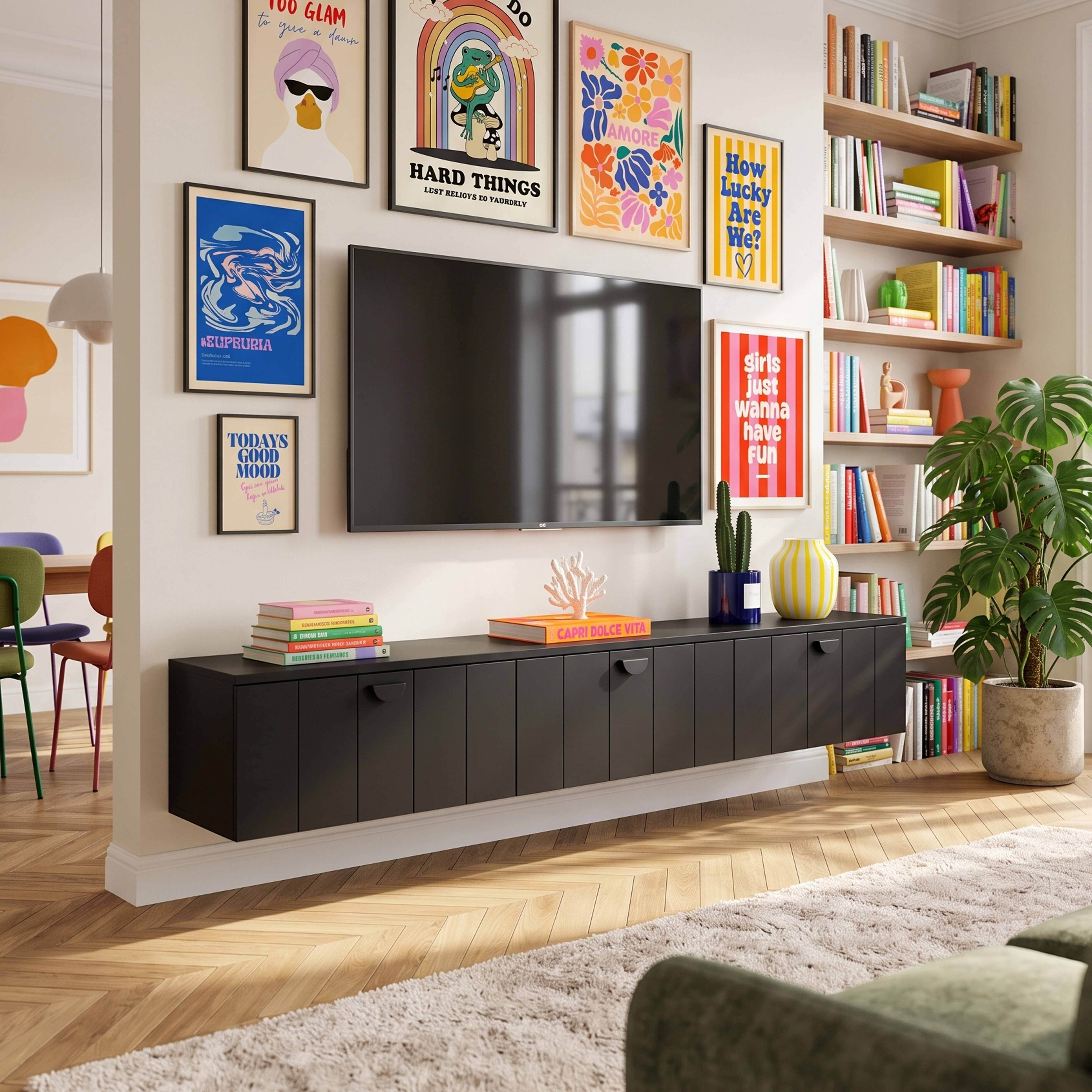 Wohnzimmer mit schwarzem TV-Schrank, Fernseher, vielen bunten Postern an der Wand, Regalen voll Büchern und einer Pflanze.
