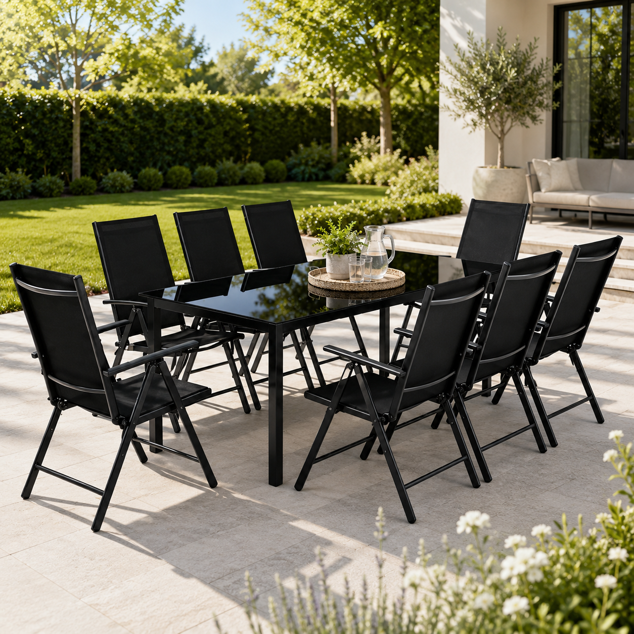 Una mesa de comedor negra con ocho sillas en un patio con un jardín verde.