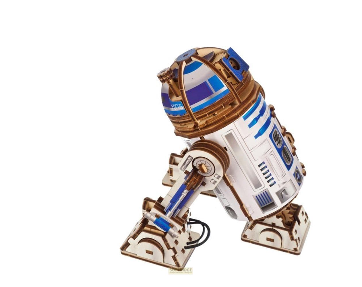 Ein hölzernes 3D-Puzzle von R2-D2 in Weiß, Blau und Braun vor schlichtem weißem Hintergrund.