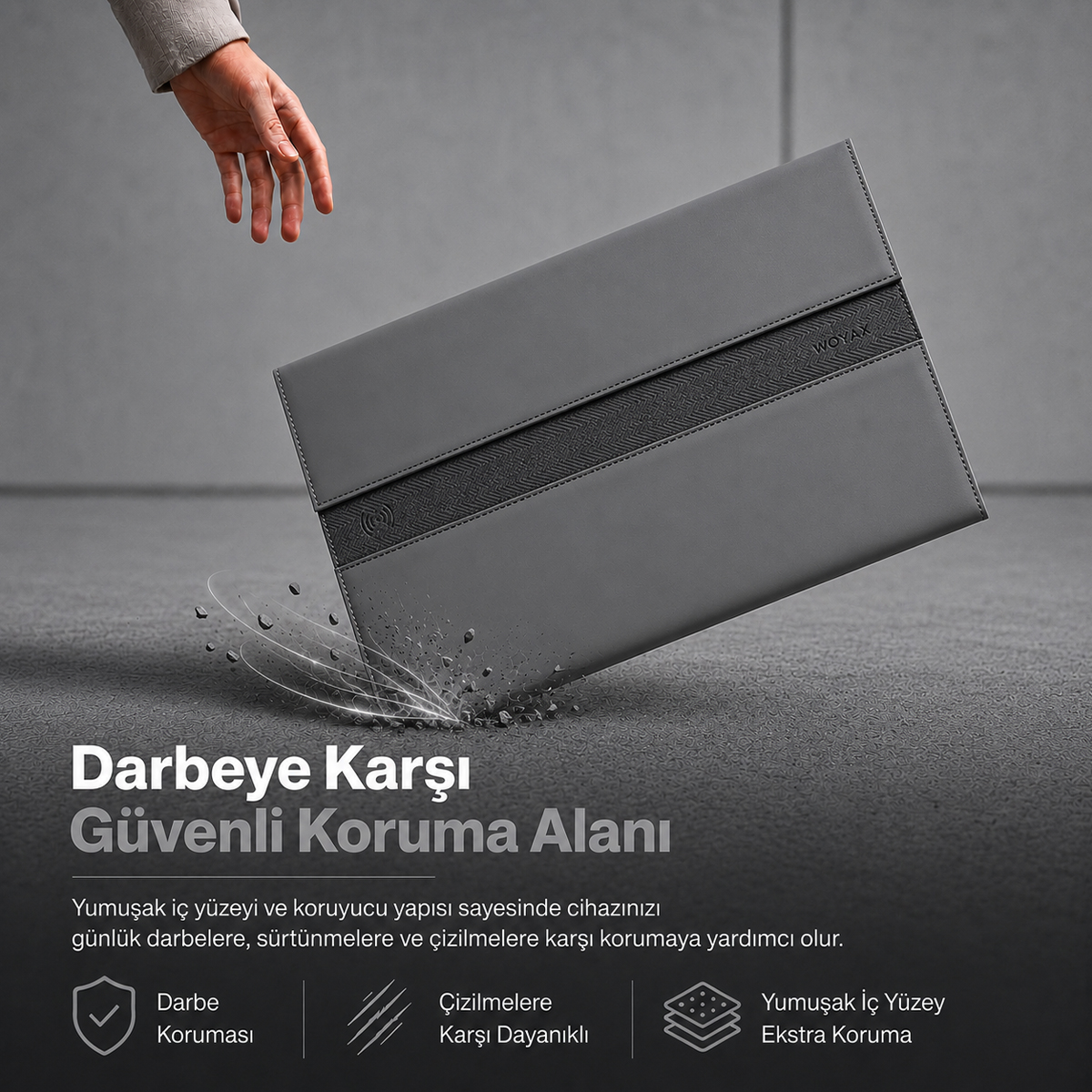 Düşen gri laptop kılıfı, köşesinde darbe efekti ve üzerinde yazılar ile.