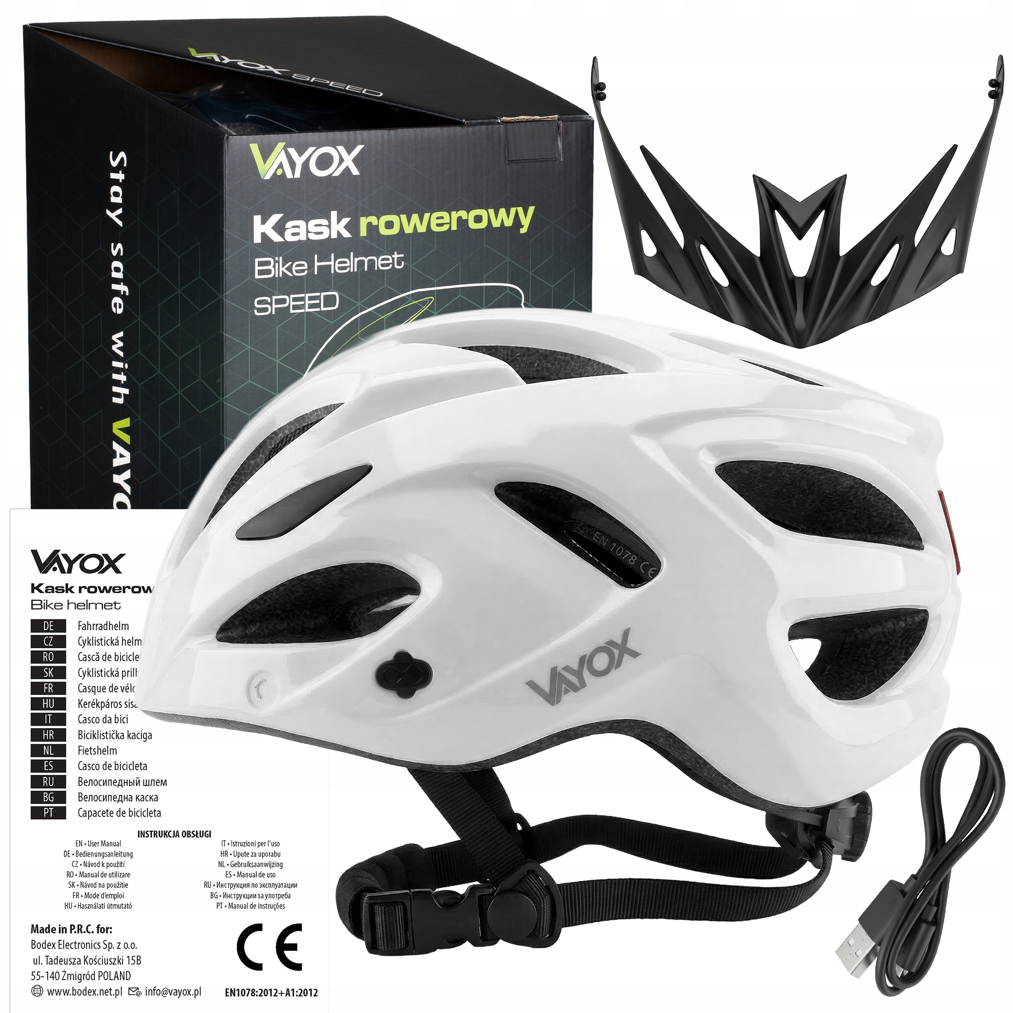 Biały kask rowerowy Vayox z pudełkiem, odczepianym daszkiem, instrukcją i kablem USB na białym tle.