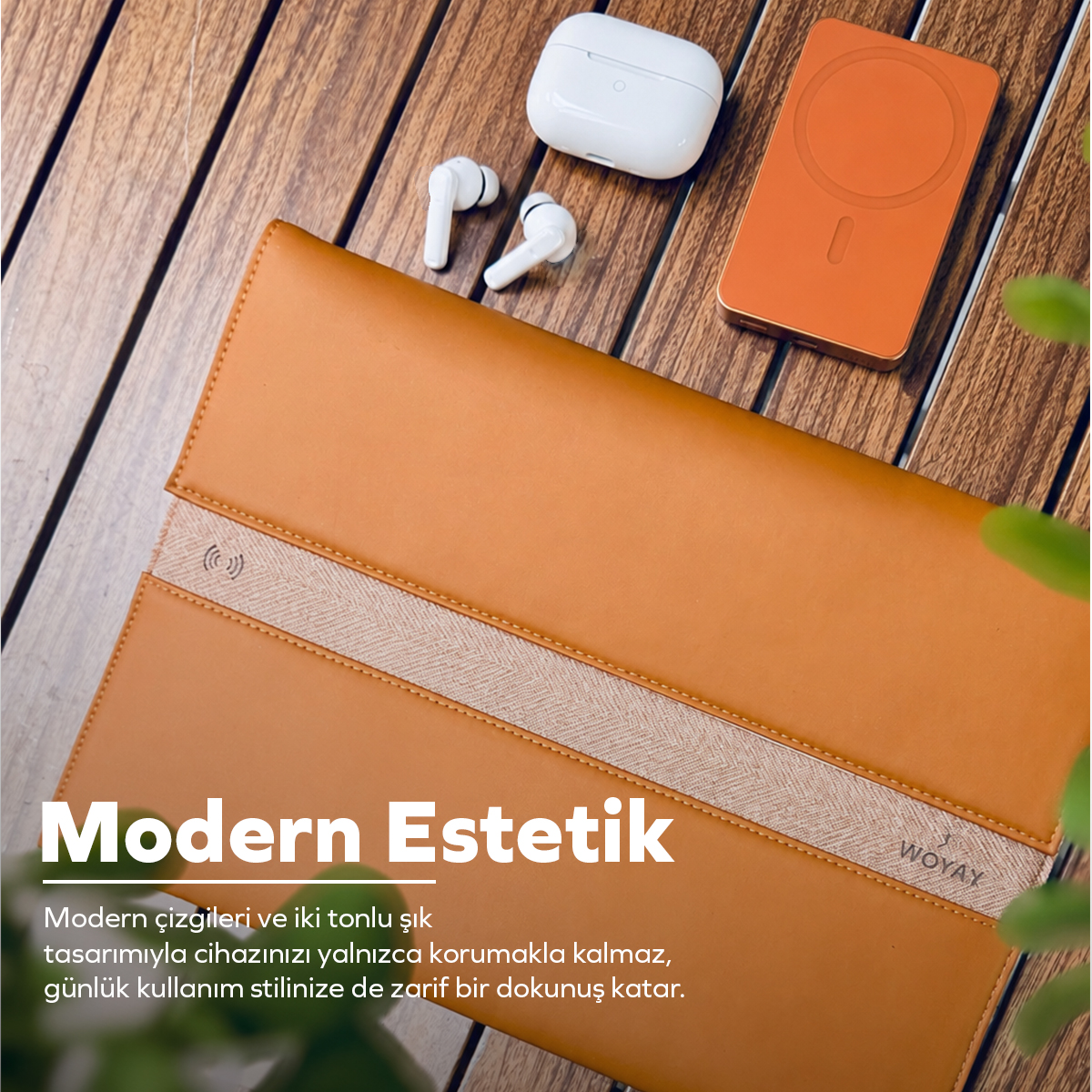 Ahşap masa üzerinde kahverengi deri dizüstü bilgisayar kılıfı, beyaz kablosuz kulaklıklar ve turuncu powerbank.