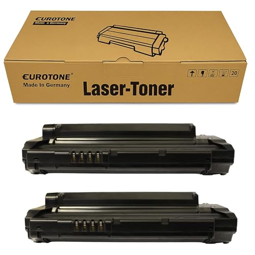 Eine braune Kartonverpackung mit der Aufschrift Laser-Toner und zwei schwarze Tonerkassetten davor.