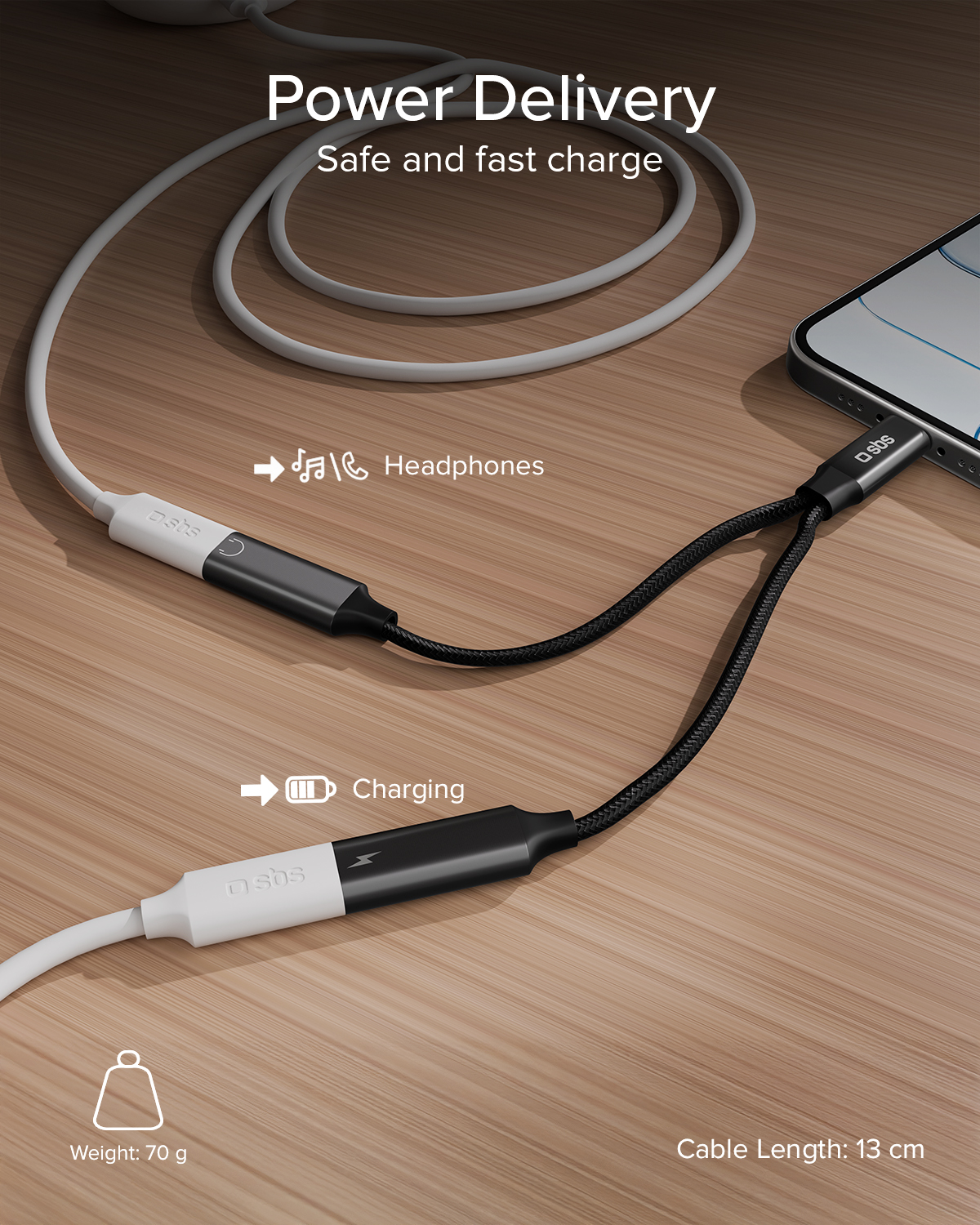 Un adaptador USB-C blanco se divide en cable de carga y conector de auriculares junto a un smartphone.