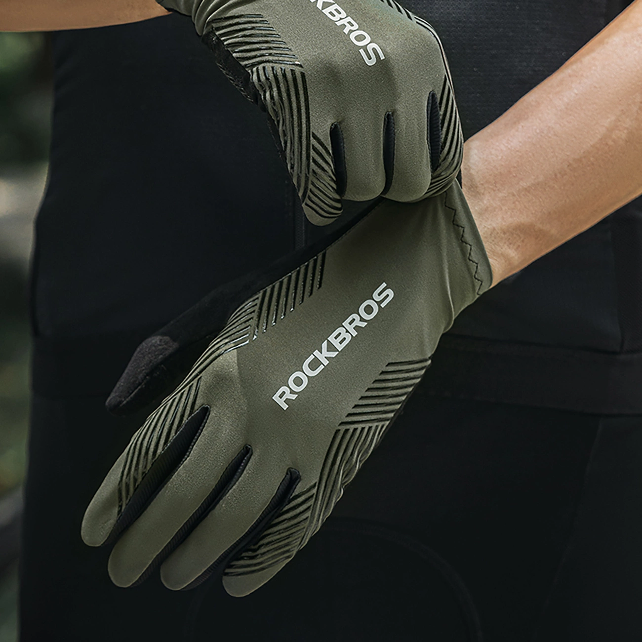 Una persona indossa guanti da ciclismo Rockbros verde oliva con dettagli neri.