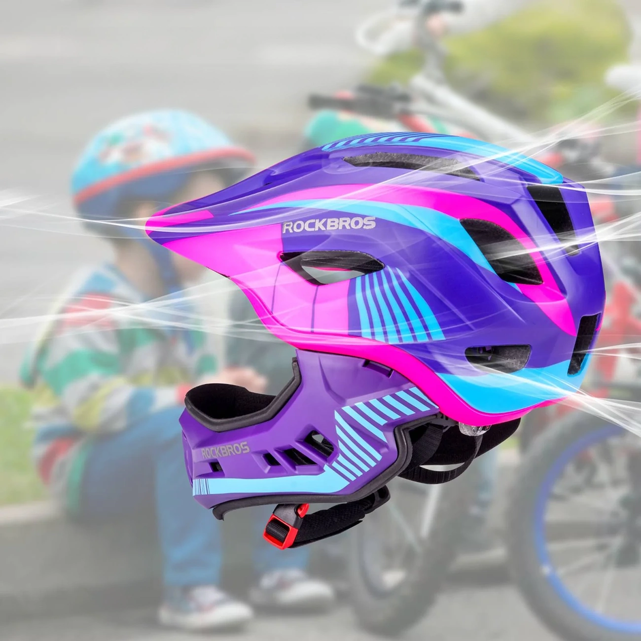 Un casco da bici Rockbros viola, blu e rosa fluttua a fuoco, con un bambino nello sfondo sfocato.