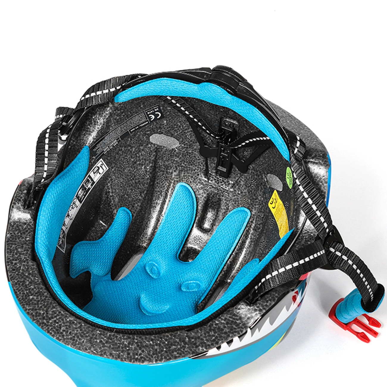Vista interna di un casco da bambino blu con imbottitura in schiuma, cinghie regolabili e fibbia rossa.
