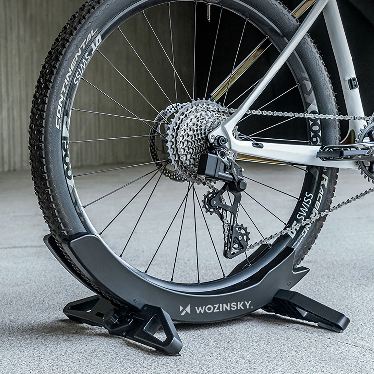 Primo piano della ruota posteriore di una bicicletta fissata in un supporto da terra Wozinsky nero.