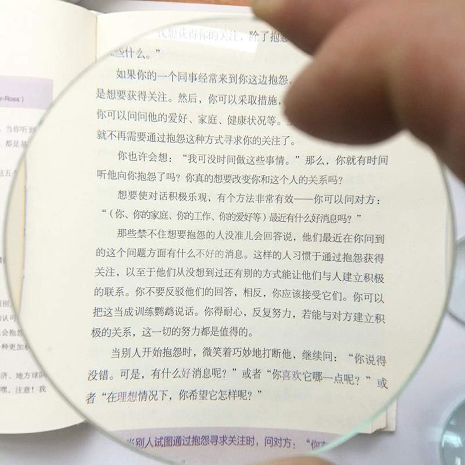 Ein Buch mit chinesischem Text wird durch eine Lupe vergrößert.