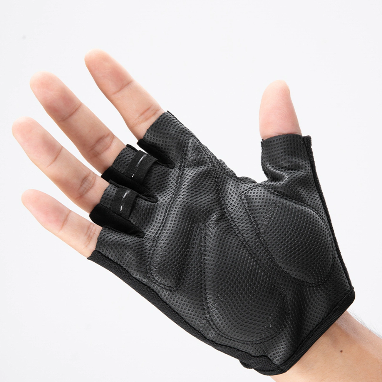 Una mano indossa un guanto da ciclismo nero senza dita con imbottitura.