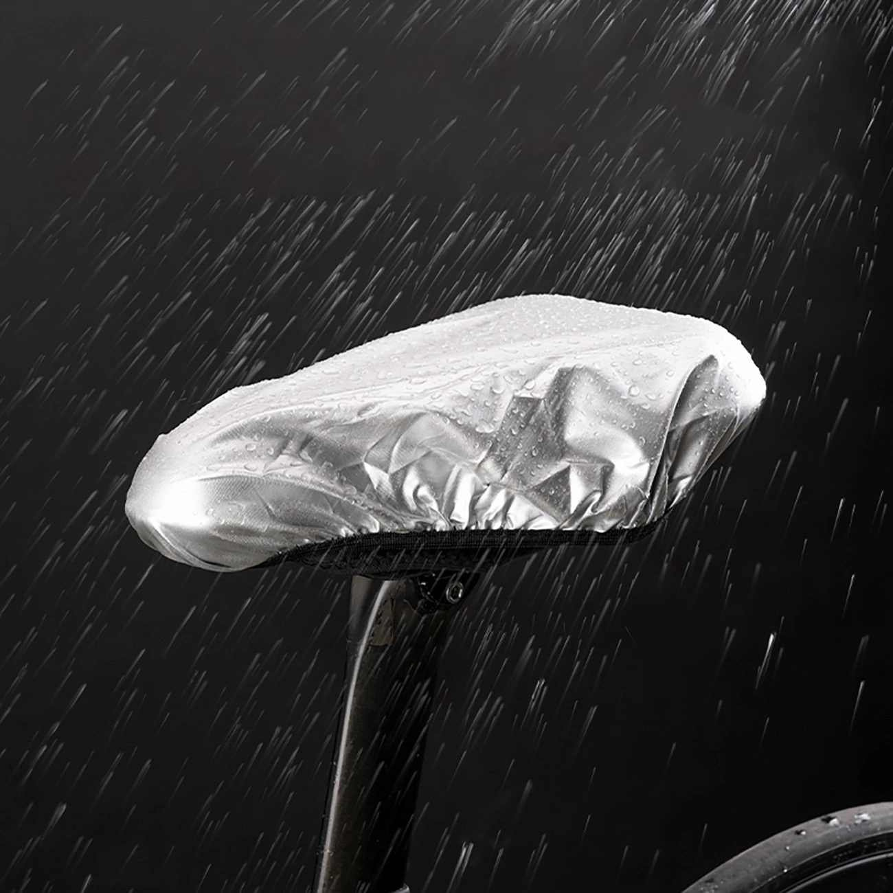 Ein silberner Fahrradsattelbezug wird im Regen vor dunklem Hintergrund getestet.
