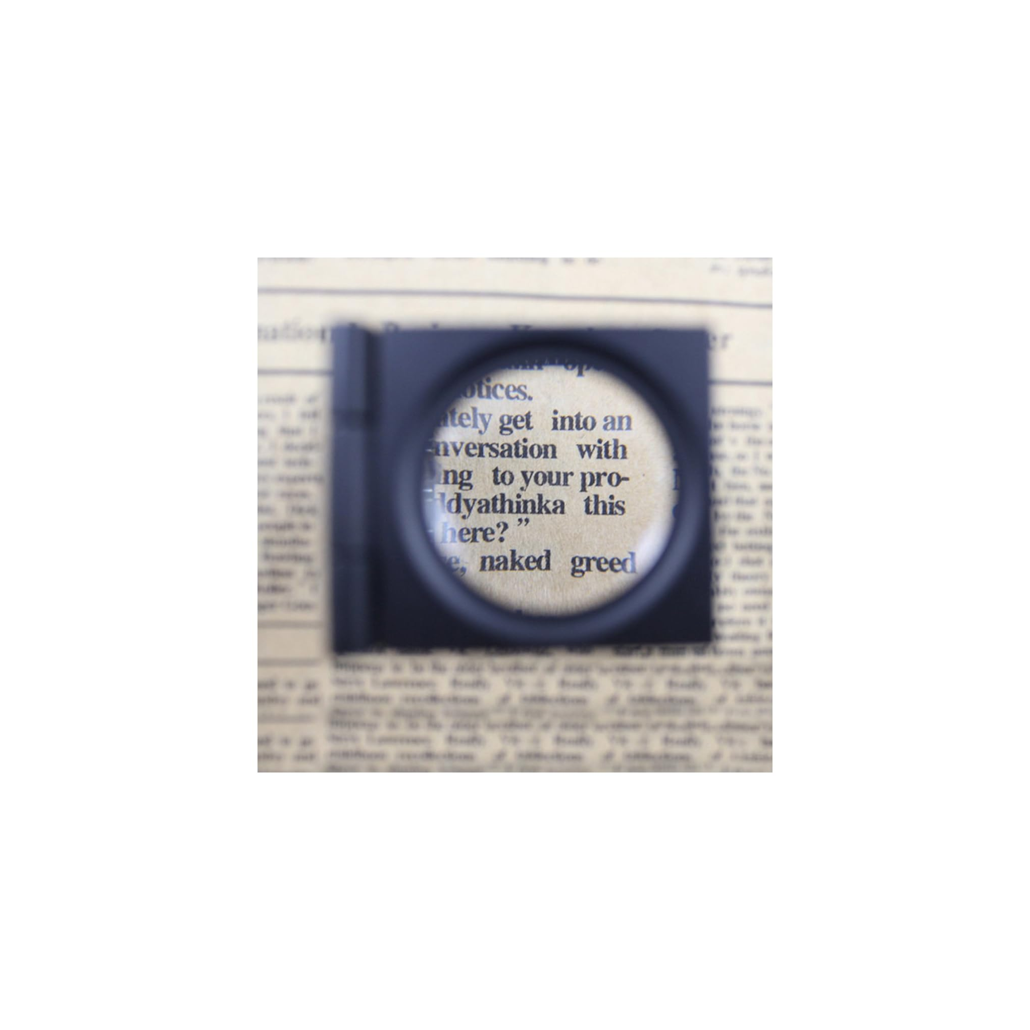 Eine quadratische Lupe vergrößert Text auf altem Zeitungspapier.