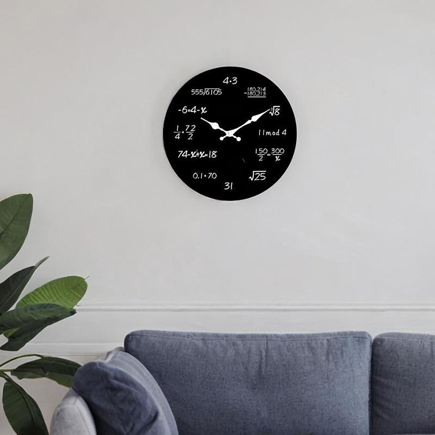 Eine schwarze Wanduhr mit mathematischen Gleichungen statt Zahlen hängt über einem grauen Sofa.