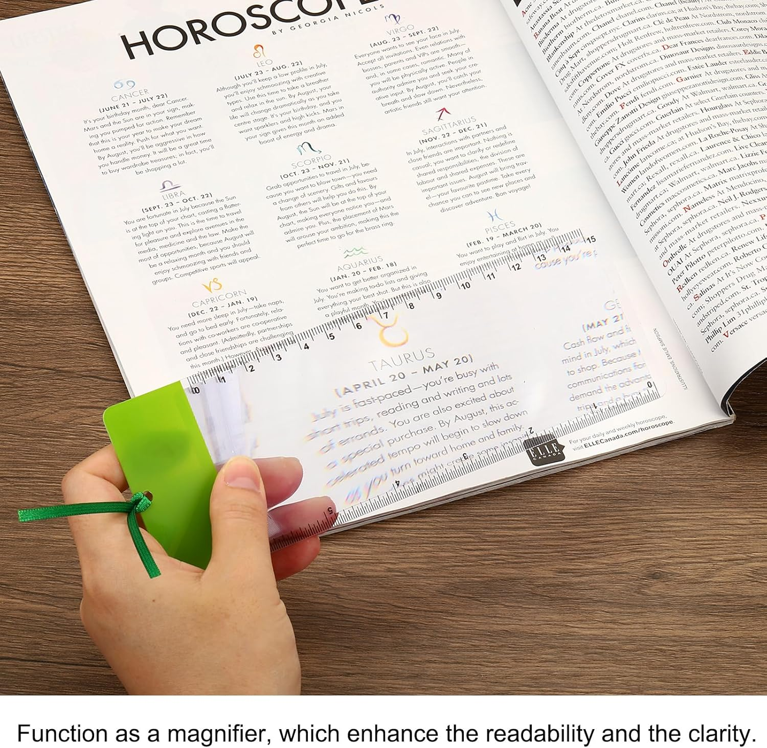 Eine handgehaltene Vergrößerungslinse zeigt den Horoskopedext eines Magazins.