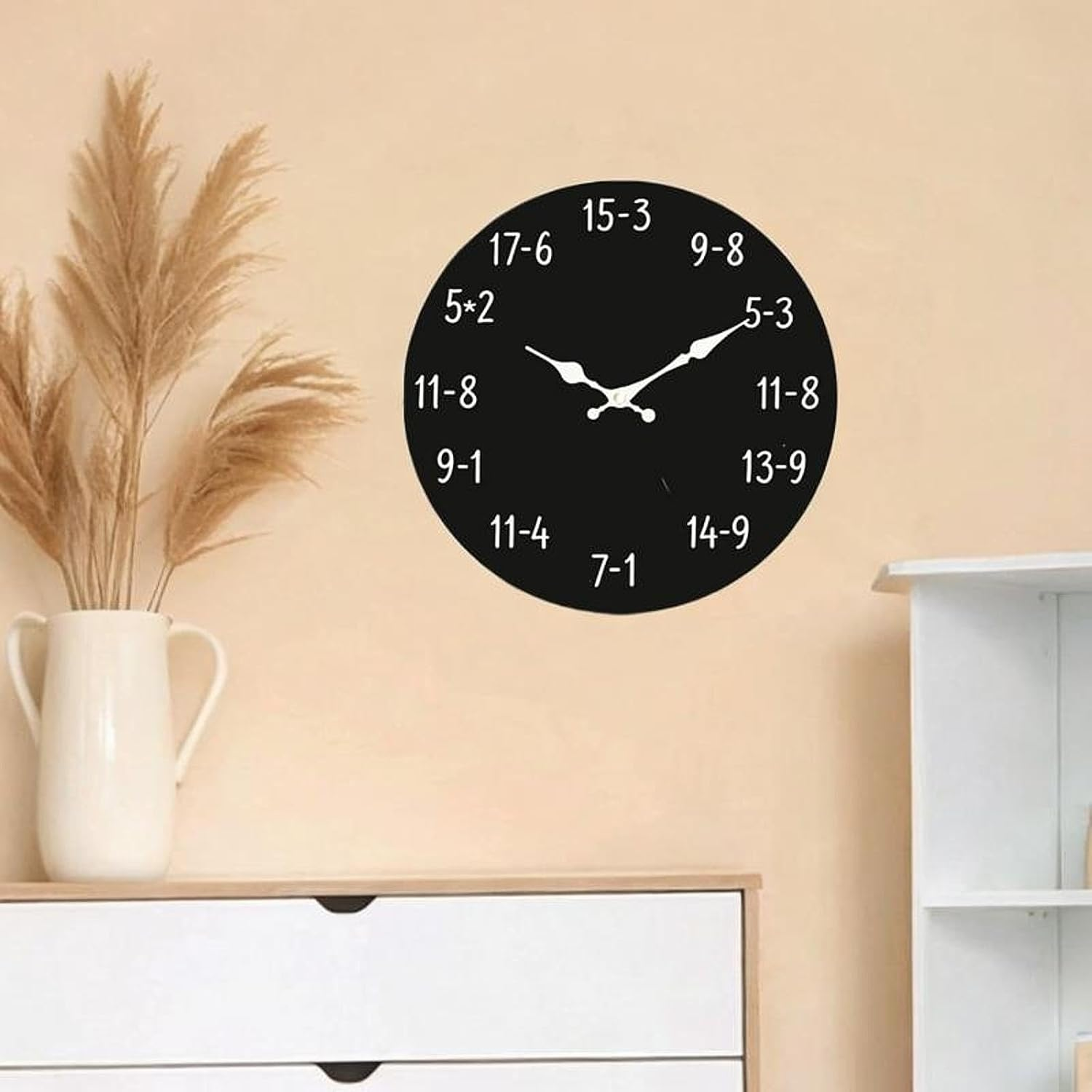 Eine schwarze Wanduhr mit mathematischen Gleichungen anstelle von Zahlen hängt an einer beigefarbenen Wand.