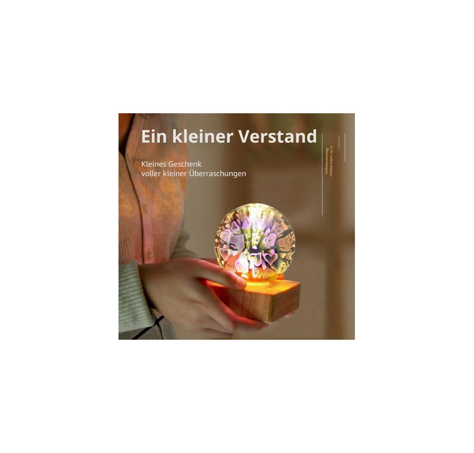 Eine leuchtende Glaskugel mit Herzen auf einem Holzsockel, gehalten von Händen, mit deutschem Text.