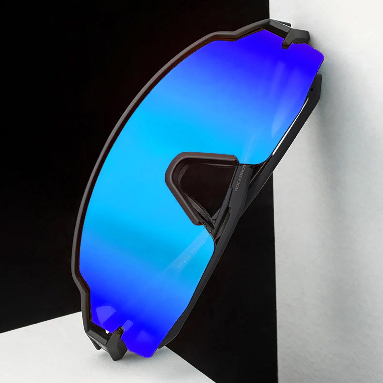 Moderne occhiali da sole sportivi con lenti a specchio blu su uno sfondo bianco e nero.
