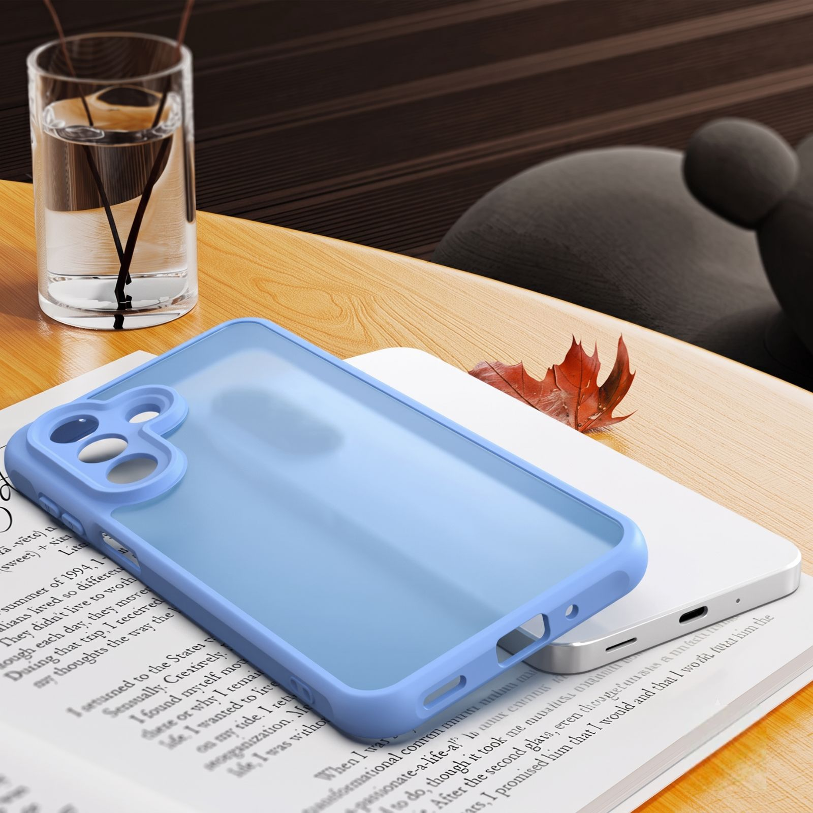 Eine blaue Handyhülle liegt auf einer offenen Buchseite auf einem Holztisch, neben einem Glas Wasser.