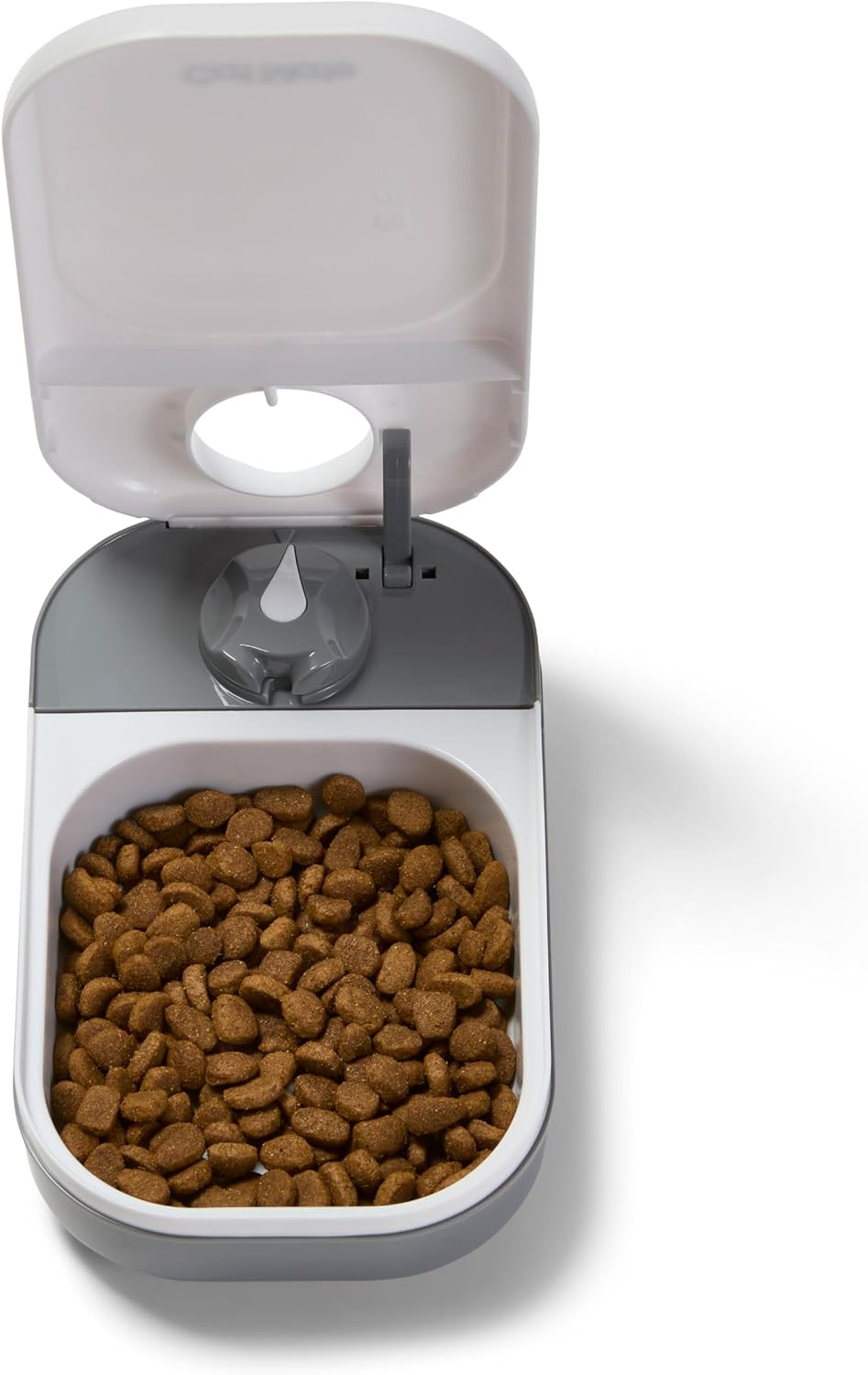 Ein weißer und grauer automatischer Haustierfütterer, gefüllt mit braunen Pellets.