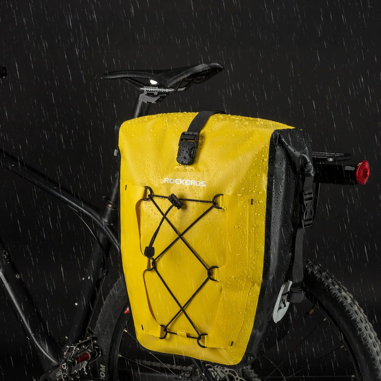 Borsa da bicicletta Rockbros gialla e nera montata su una bici sotto la pioggia.