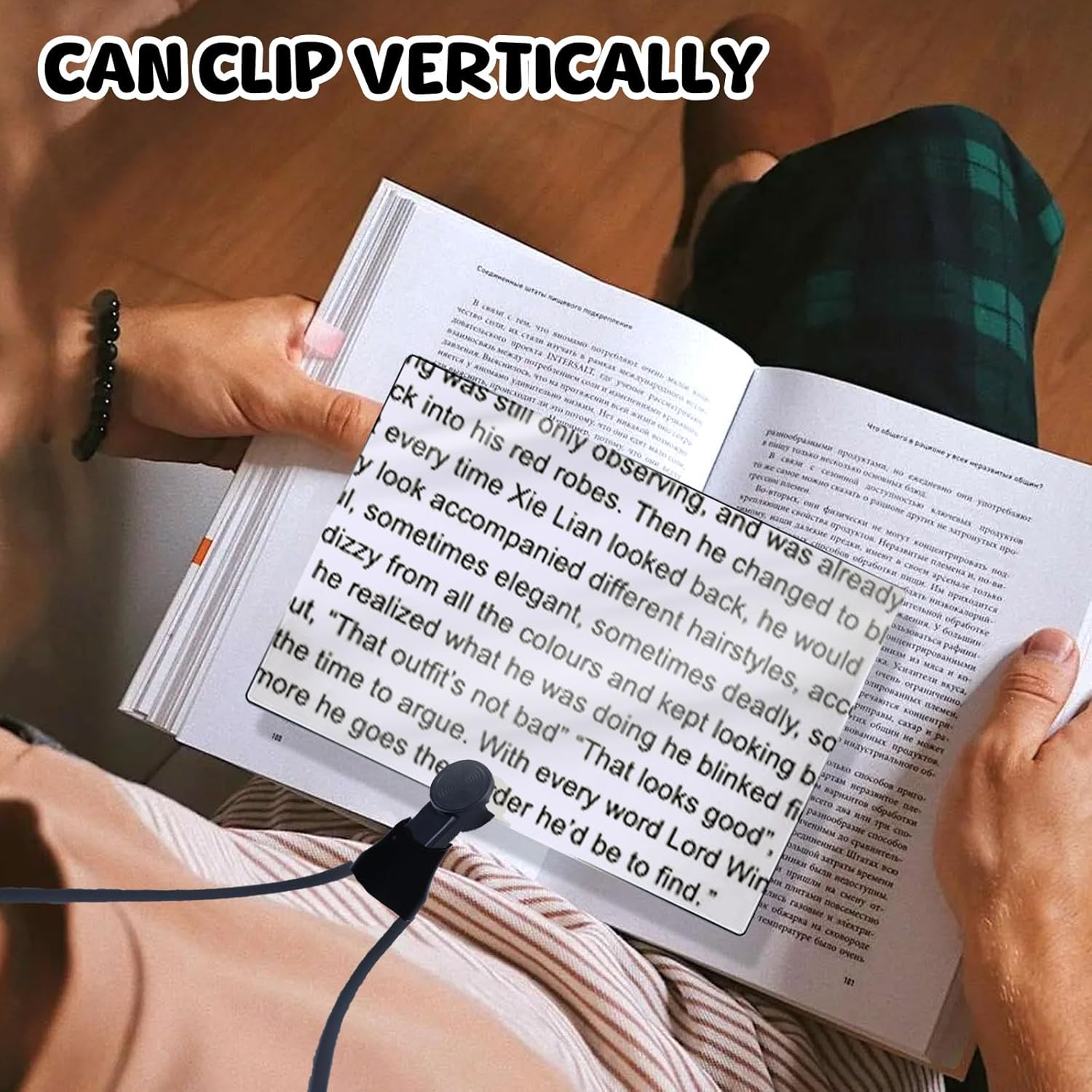 Eine Person liest ein Buch, während ein kleiner schwarzer Clip am Rand befestigt ist.