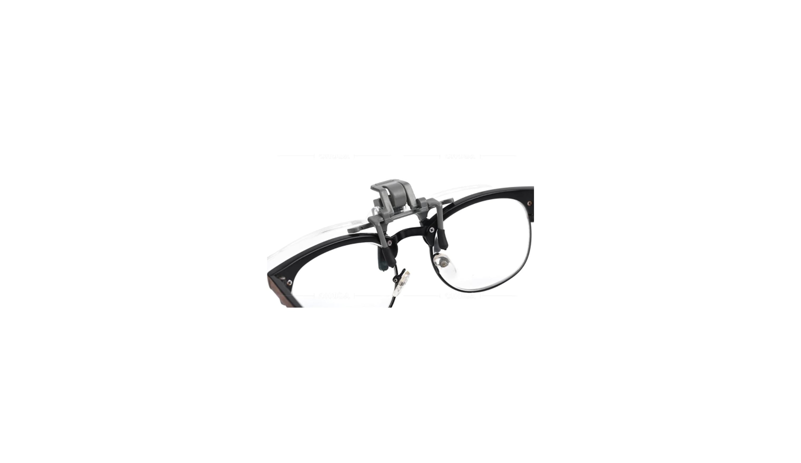Nahaufnahme einer Brille mit einem grauen Clip-on-Aufsatz auf dem Nasensteg.