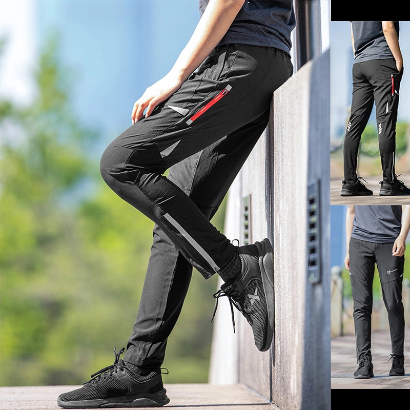 Una persona indossa pantaloni della tuta neri con tasche rosse con zip e scarpe da ginnastica nere.