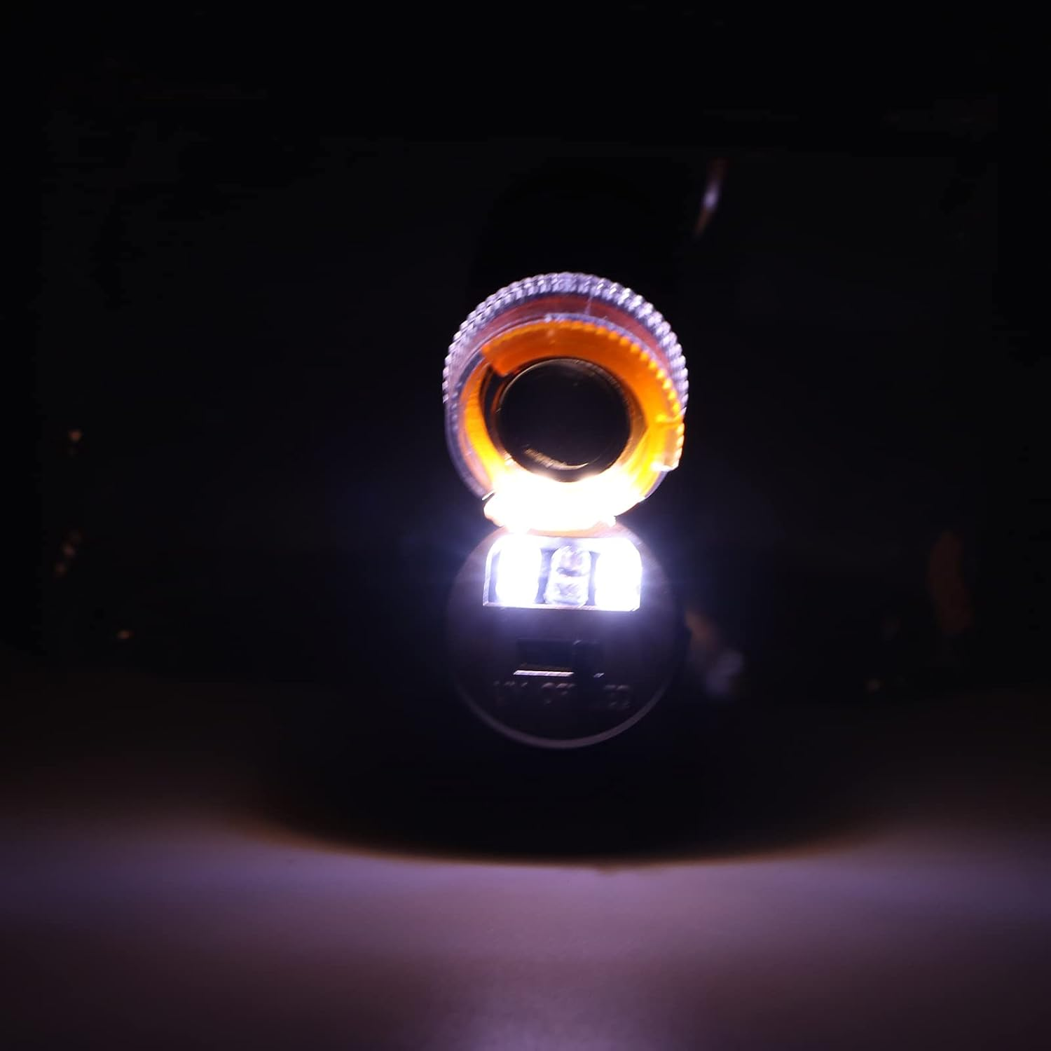 Ein leuchtendes Autoladegerät im Dunkeln mit hellen weißen LEDs und einem warmen orangen Ringlicht.