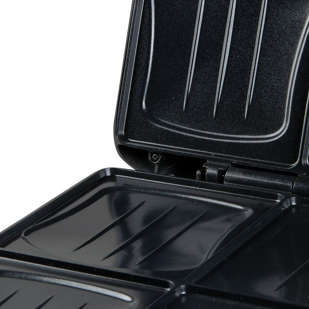 Ein offener schwarzer Sandwichmaker mit antihaftbeschichteten, gerillten Heizplatten.