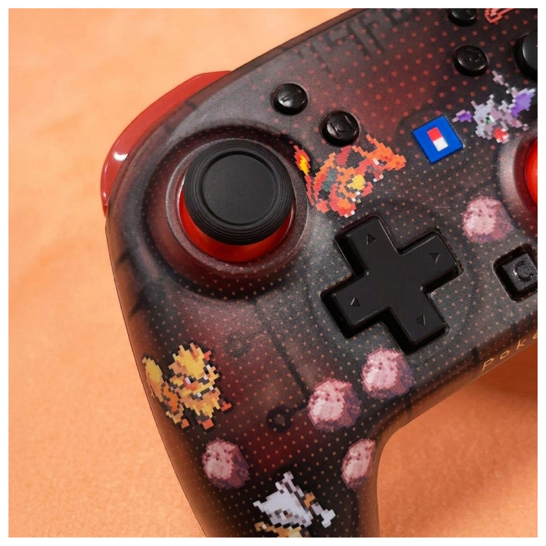 Ein schwarz-roter Pokemon-Gamecontroller mit Pixel-Art-Figuren und einem D-Pad.