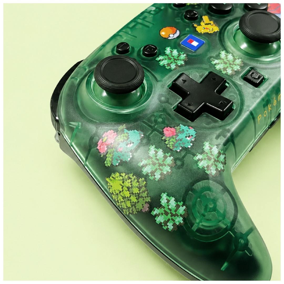 Grüner, transparenter Gamecontroller mit Pokémon-Pixelkunstmotiven auf hellgrünem Hintergrund.
