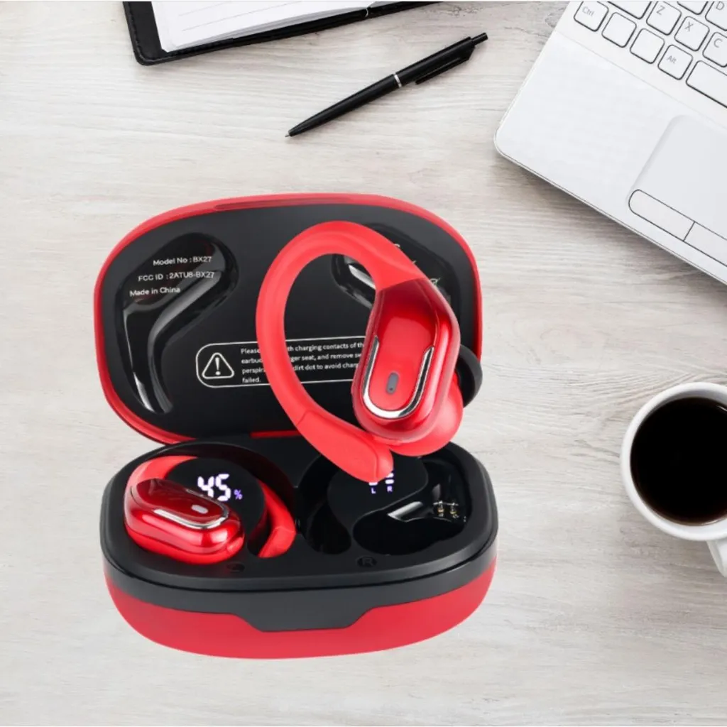 Rote kabellose Sport-Ohrhörer in Ladebox auf Schreibtisch mit Laptop, Stift und Kaffee.