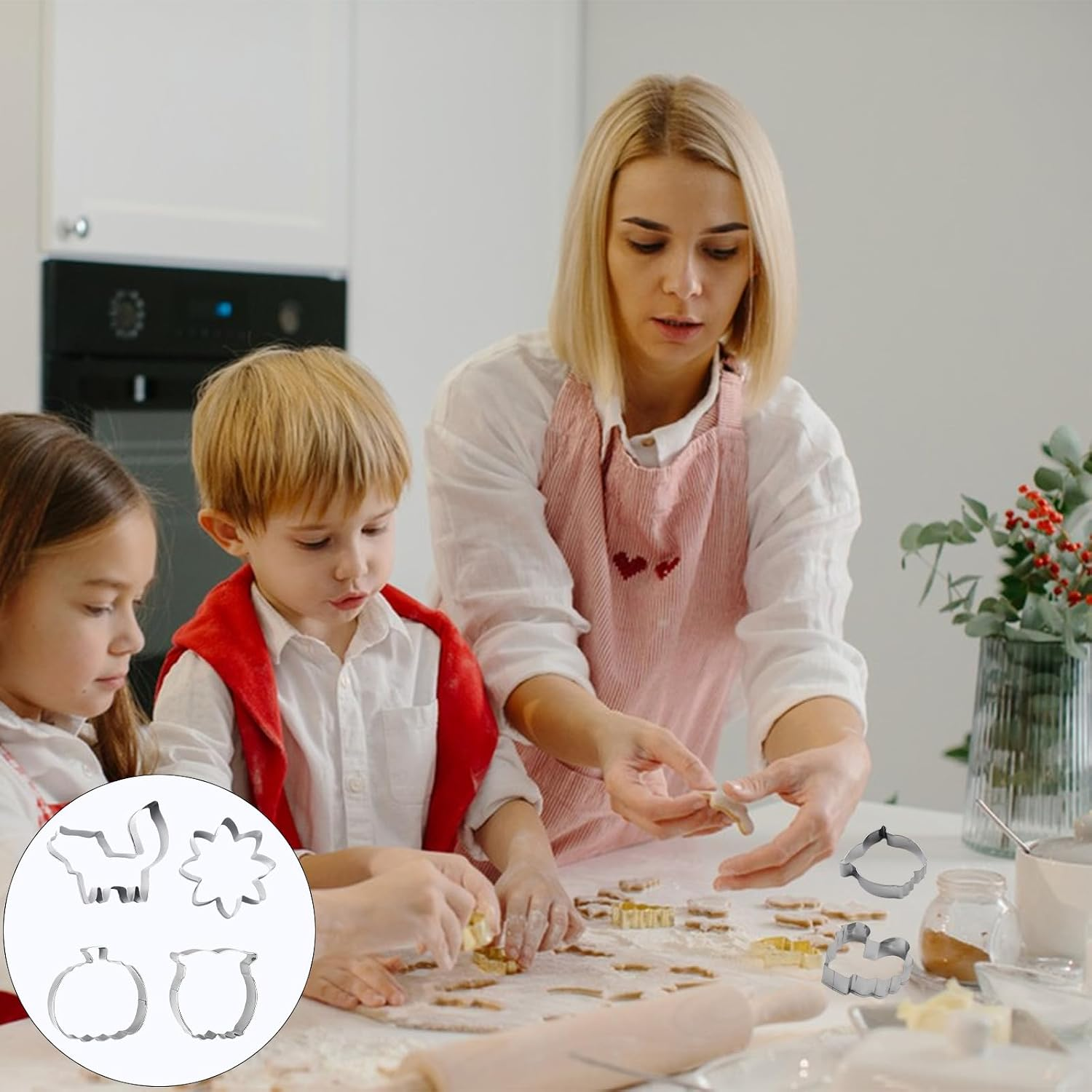 Frau und Kinder backen Plätzchen in einer weißen Küche, daneben Plätzchenformen.