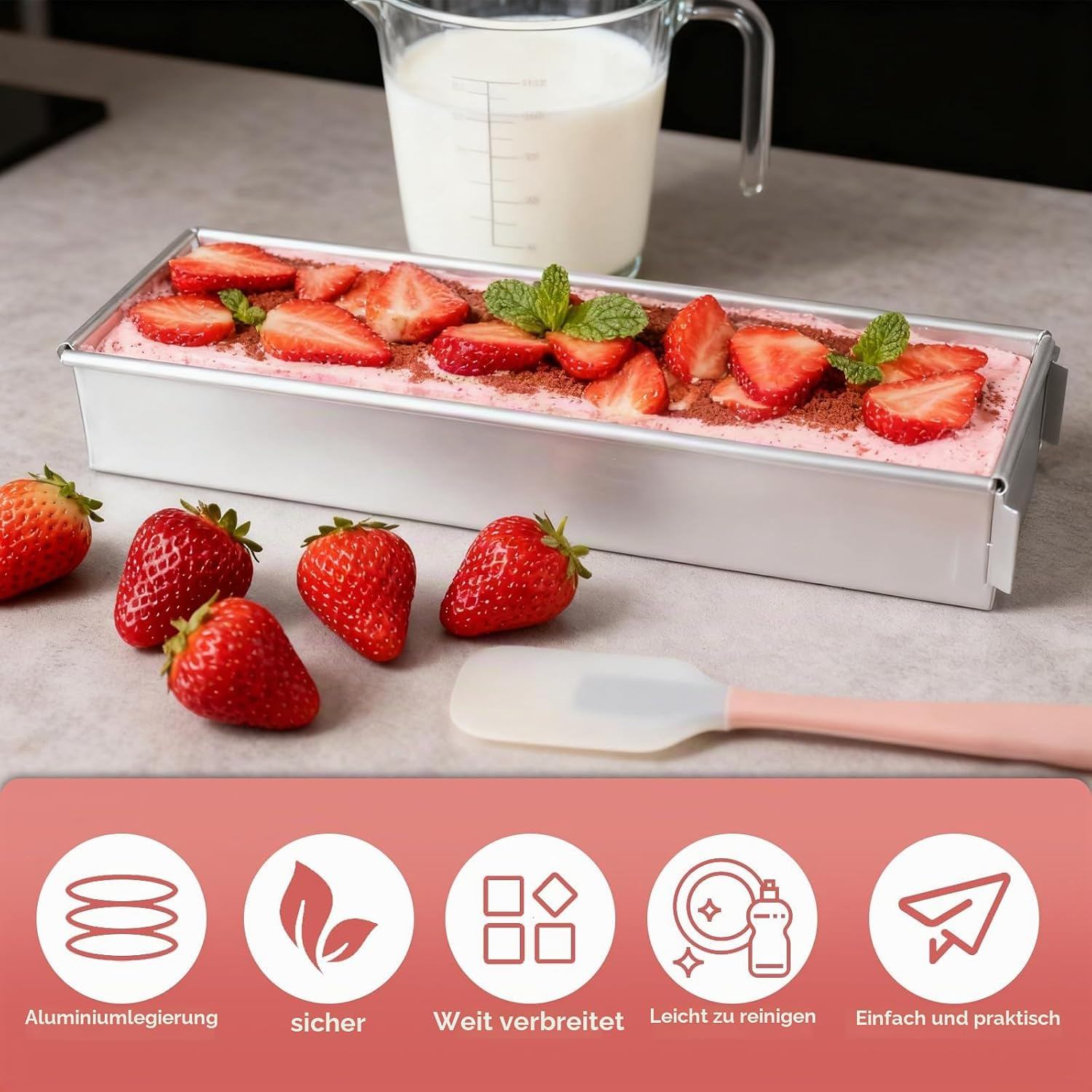 Eine rechteckige Kastenform mit rosa Dessert, belegt mit Erdbeerscheiben und Minze, neben frischen Erdbeeren.