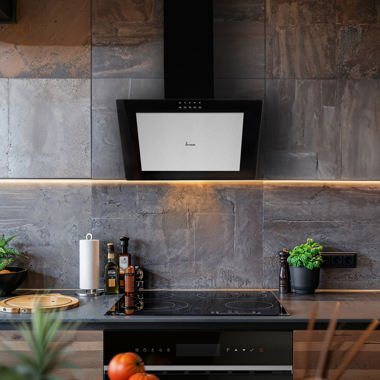 Cucina moderna con cappa nera sopra il piano cottura, paraschizzi in pietra e piante sul bancone.