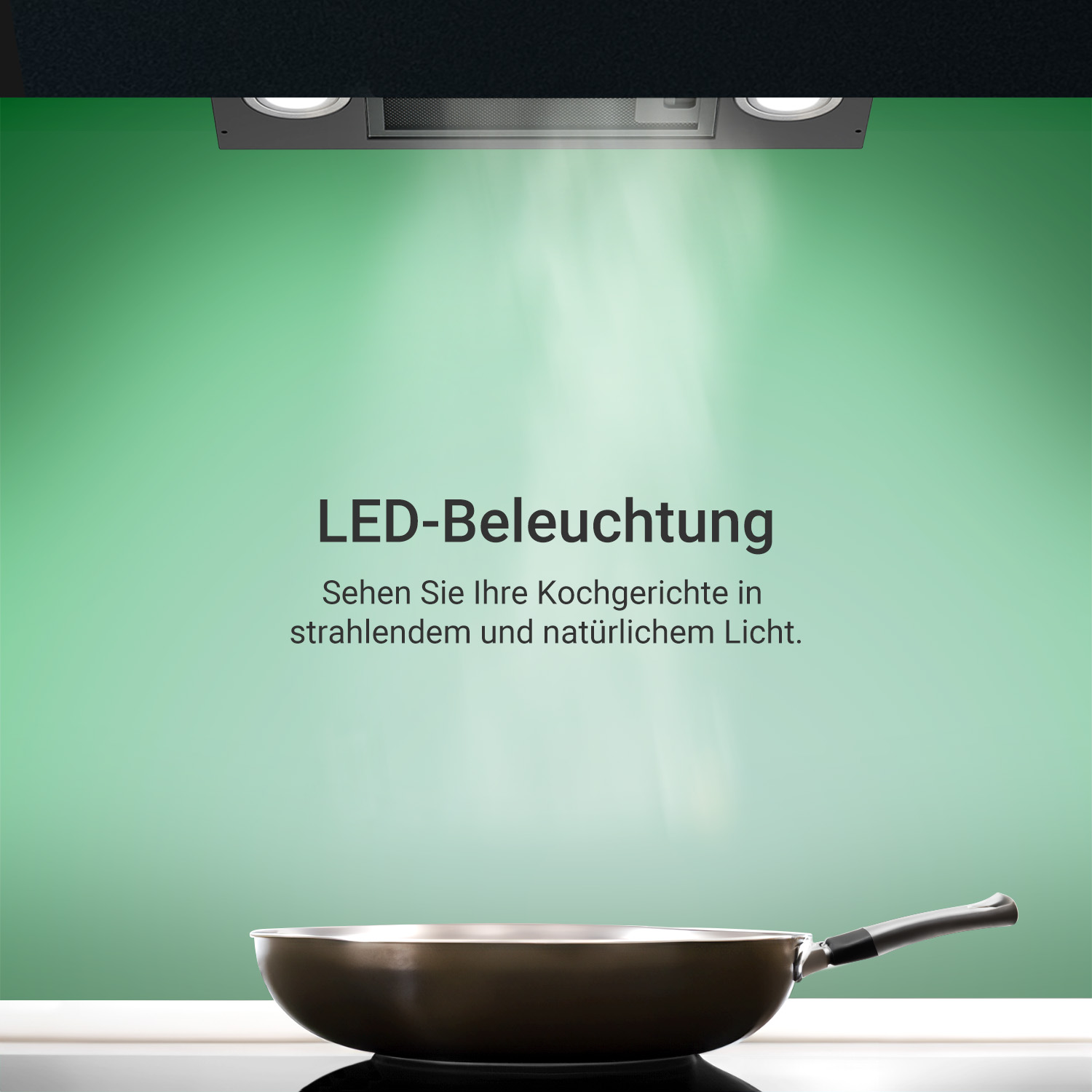 Una padella su un piano cottura sotto una cappa illuminata contro una parete verde.