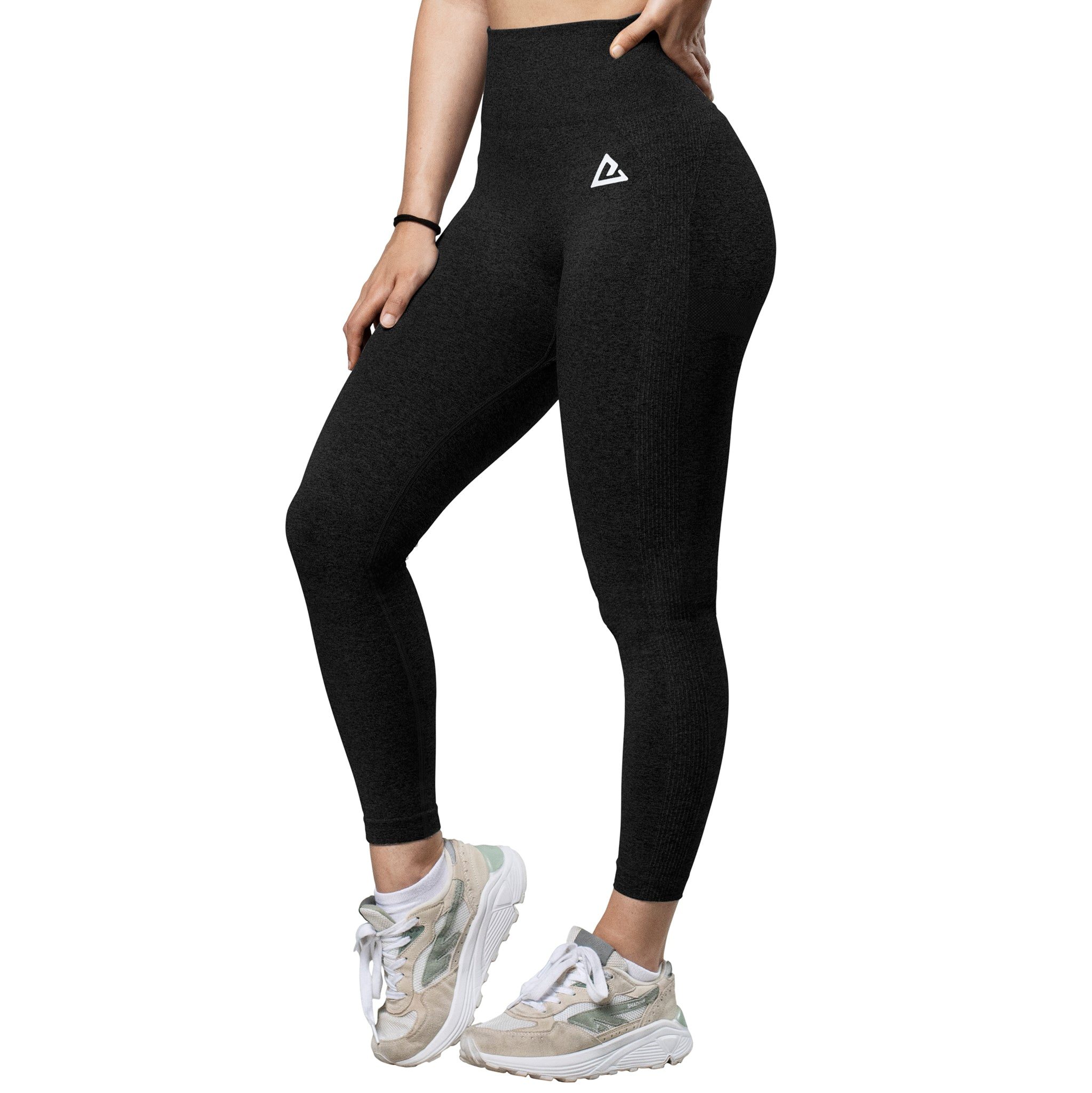 Una persona con leggings negros de tiro alto y zapatillas blancas sobre fondo blanco.