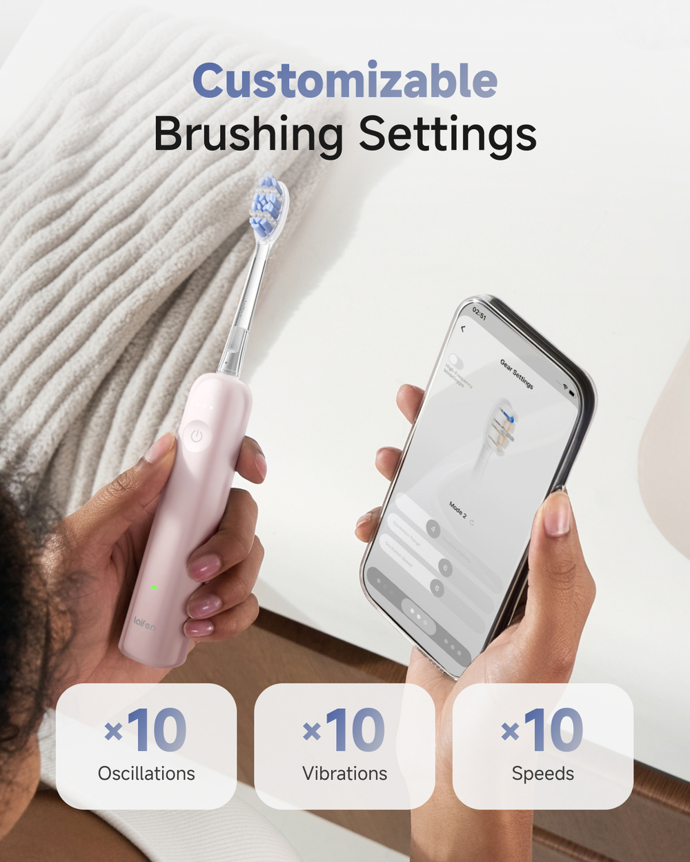 Personne tenant une brosse à dents électrique rose et un smartphone avec application.