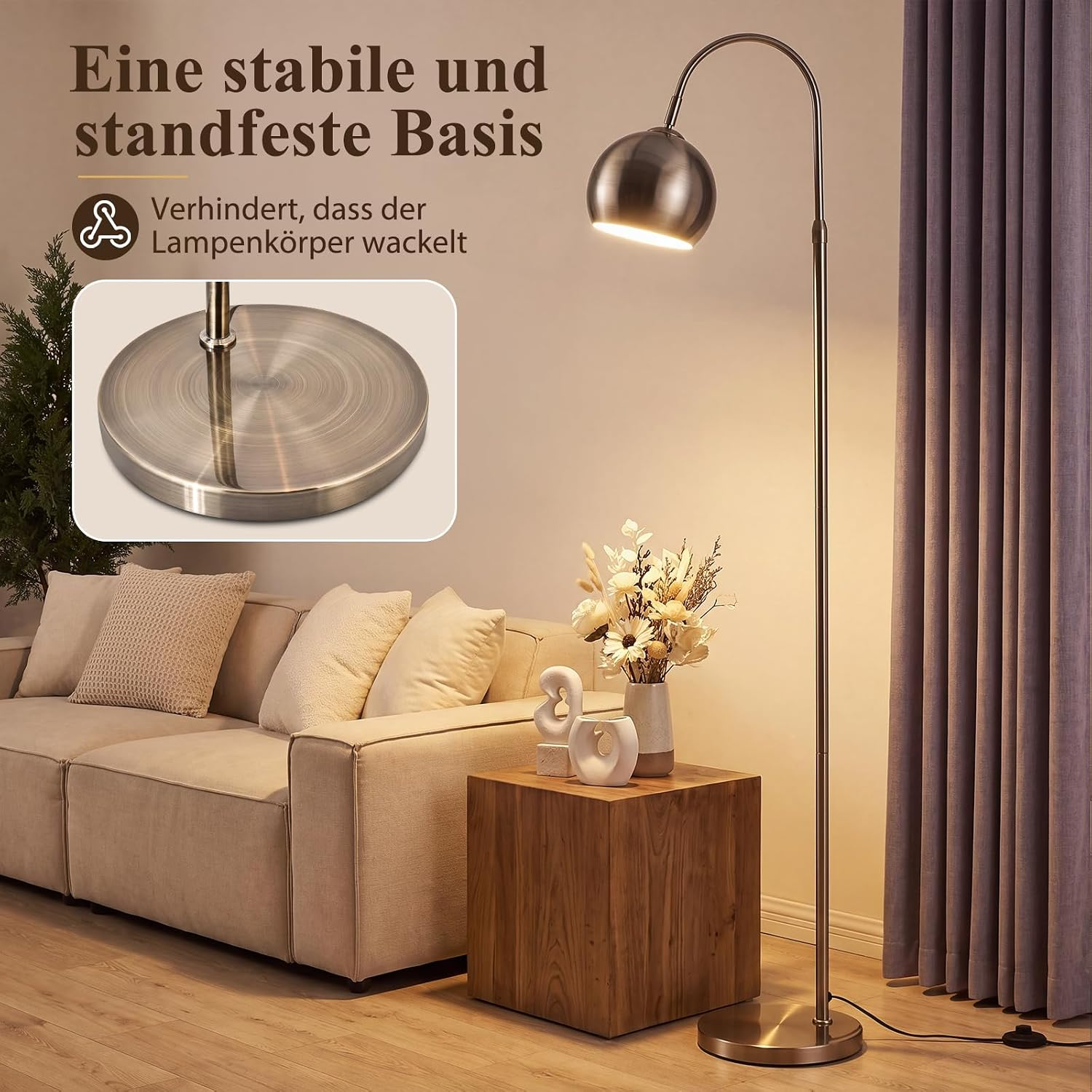 Una lámpara de pie arqueada plateada con base pesada junto a un sofá claro en una sala de estar.
